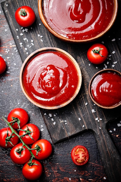 Tomatensauce auf einem Holzbrett mit Salzstücken