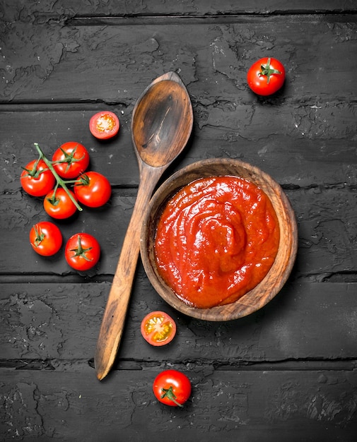 Tomatensauce in Schüssel und Holzlöffel