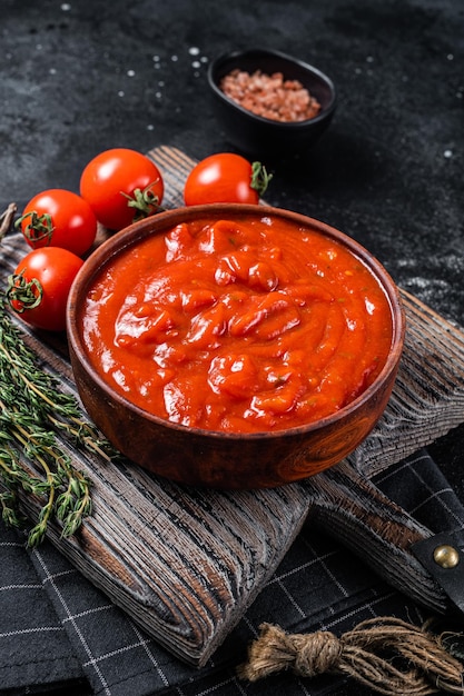 Tomatensauce Passata traditionelle Sauce für italienische Küche Schwarzer Hintergrund Ansicht von oben