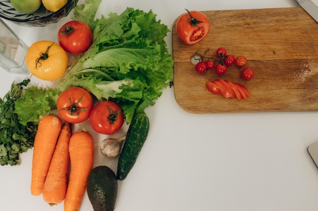 Tomatenscheiben auf einem Küchenbrett Viel Gemüse auf dem Tisch