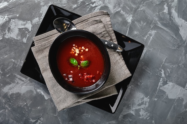 Tomatensuppe in einer schwarzen Schüssel auf einem grauen Stein Blick von oben