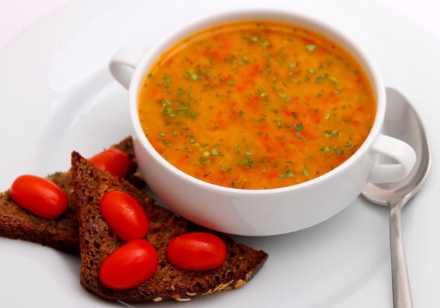 Foto tomatensuppe mit crackern und kräutern