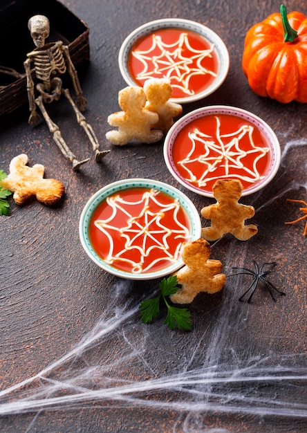 Tomatensuppe und Brot in Form von Männern. Halloween-Leckereien für die Party.