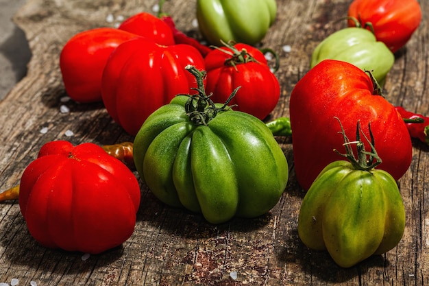 Tomates acanalados verdes y rojos en un soporte de madera vintage Variedad americana o florentina