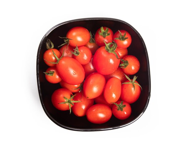 Tomates aislados Montón de tomates cherry en un recipiente de vidrio aislado sobre fondo blanco.