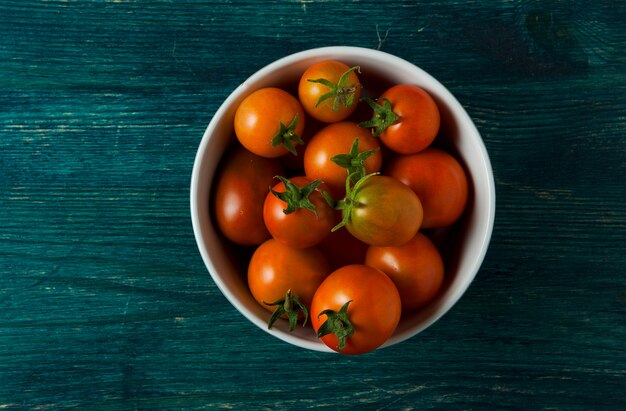 Tomates, ajo en una superficie de madera.