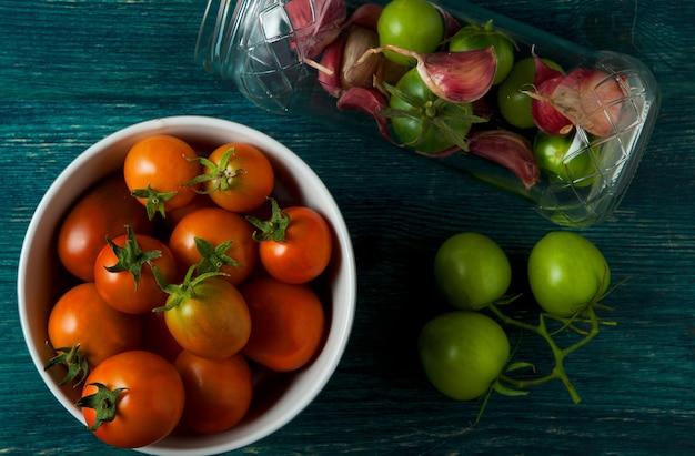 Tomates, ajo en una superficie de madera.