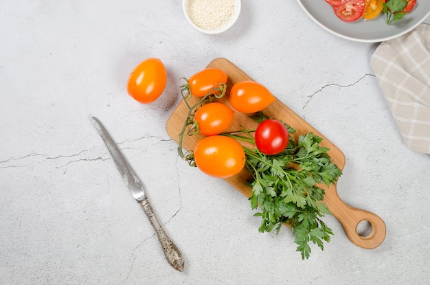 Tomates amarelos e vermelhos em ingredientes de tábua para cozinhar