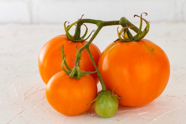 Tomates amarillos maduros sobre un fondo blanco.