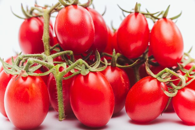 Foto tomates apilados en blanco en primer plano