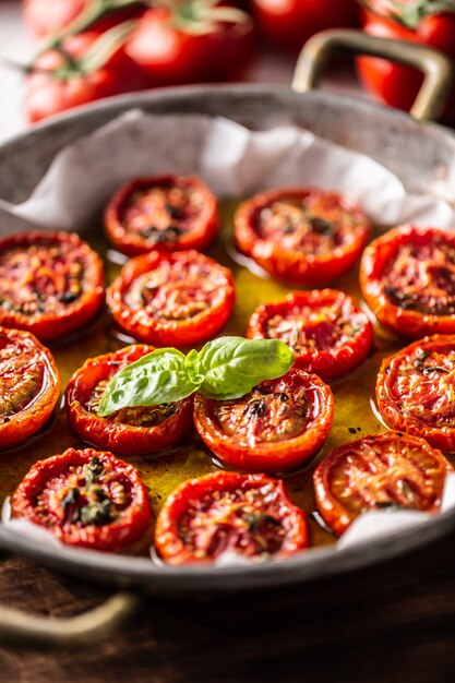 Tomates assados com azeite de tomilho orégano e manjericão na panela.