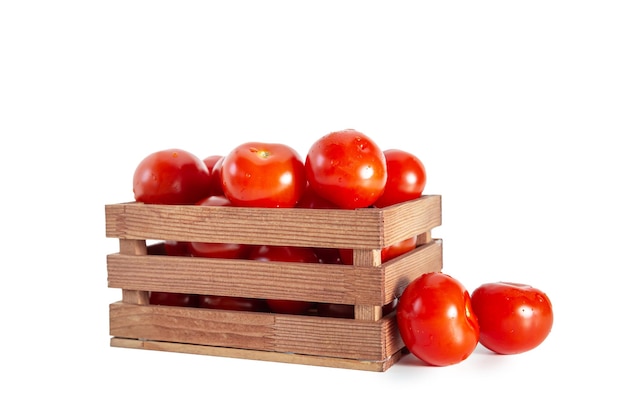 Tomates en una caja de madera aislados sobre un fondo blanco Concepto de alimentación saludable