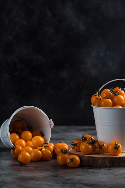 Tomates cereja e laranja no balde