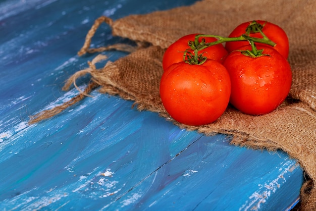 Tomates cereja maduros frescos na placa de madeira azul horizontal