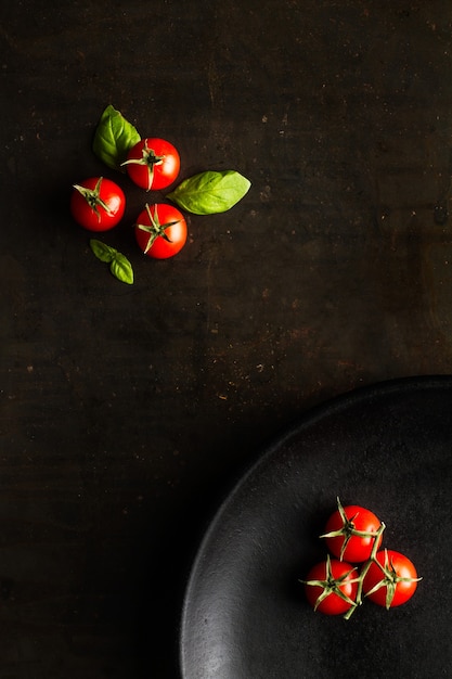 Tomates cereja vermelhos em uma placa preta em uma vista superior