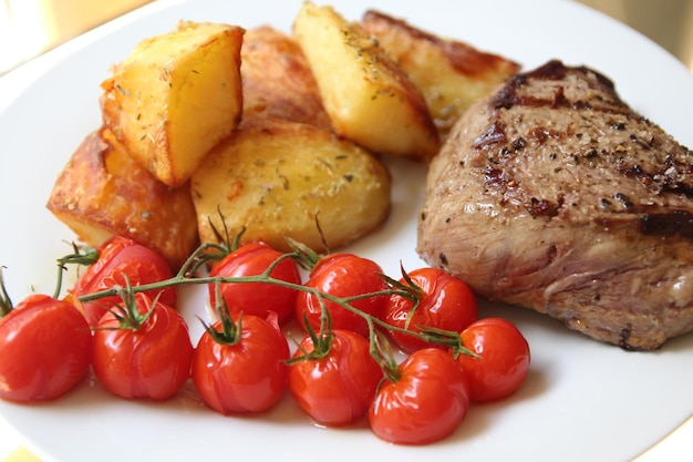 Tomates de cereza y bistec en el plato