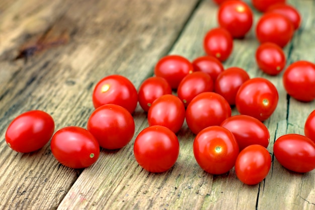 Tomates de cereza maduros frescos en viejo fondo de madera.