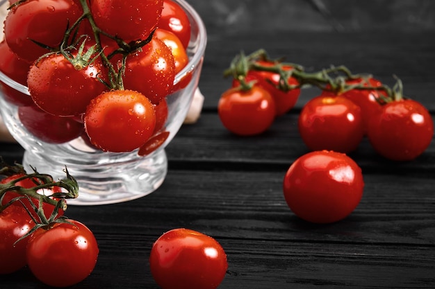 Foto tomates de cereza orgánicos frescos en un fondo oscuro espacio de copia de entrega de alimentos