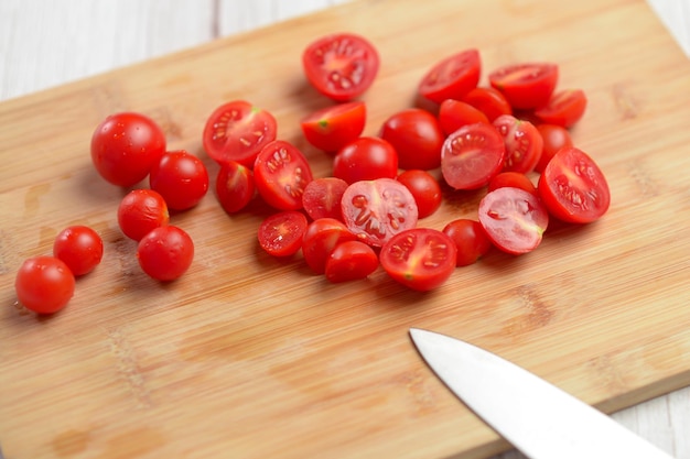 Tomates de cereza recién cortados en una tabla de bambú de tonos rojos vibrantes