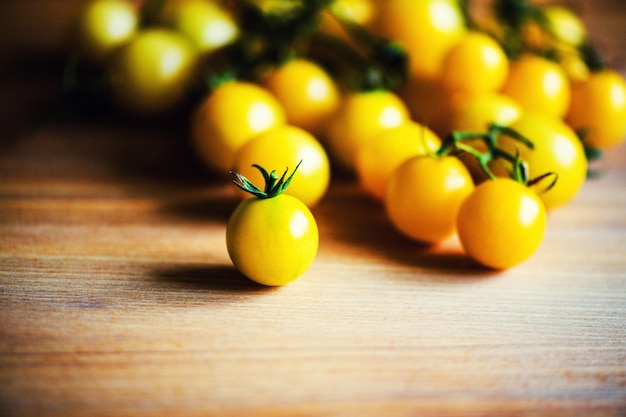 Tomates cherry amarillos sobre fondo de madera
