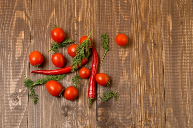 Tomates cherry frescos, chile y eneldo para la merienda están sobre la mesa