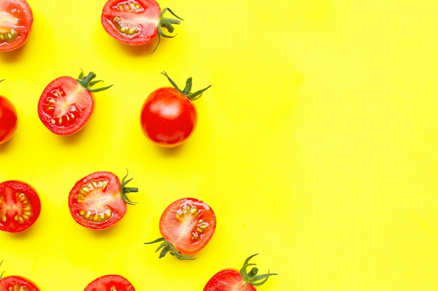 Tomates cherry frescos, entero y medio corte aislado en amarillo.