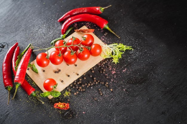 Tomates cherry frescos con especias sobre fondo negro