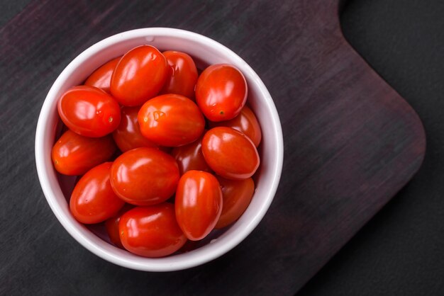 Tomates cherry frescos y sabrosos en un recipiente acanalado blanco