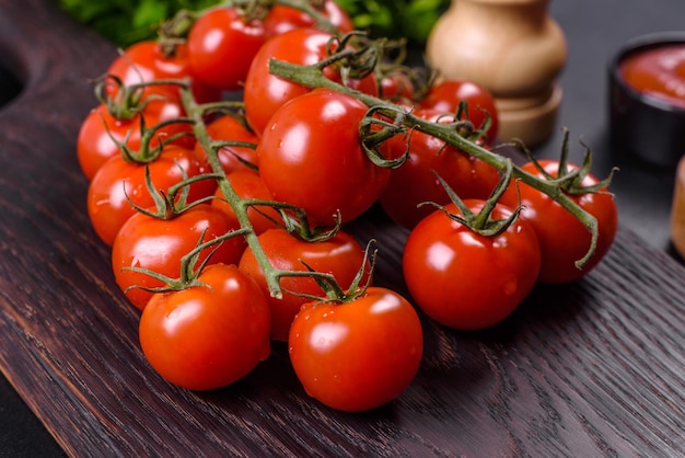 Tomates cherry frescos sobre un fondo negro con especias