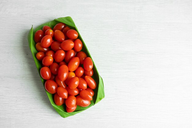 Tomates cherry en una hoja de plátano. Embalaje ecológico