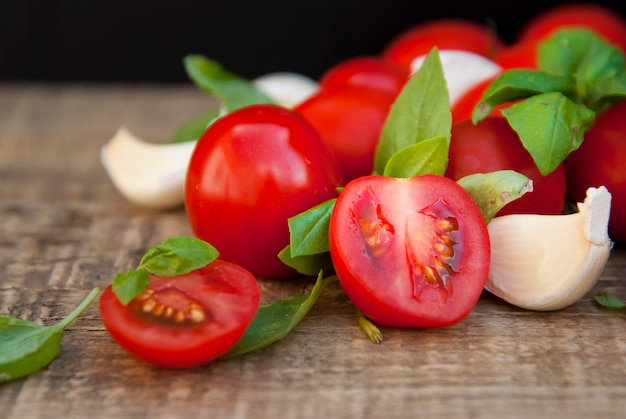 Tomates cherry con hojas de albahaca y ajo.