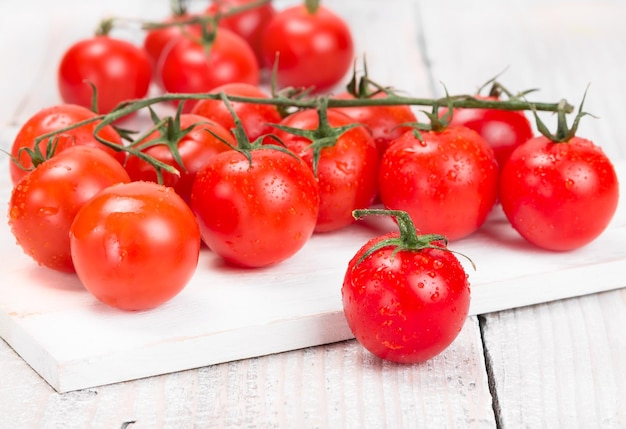 Tomates cherry maduros en una pizarra blanca