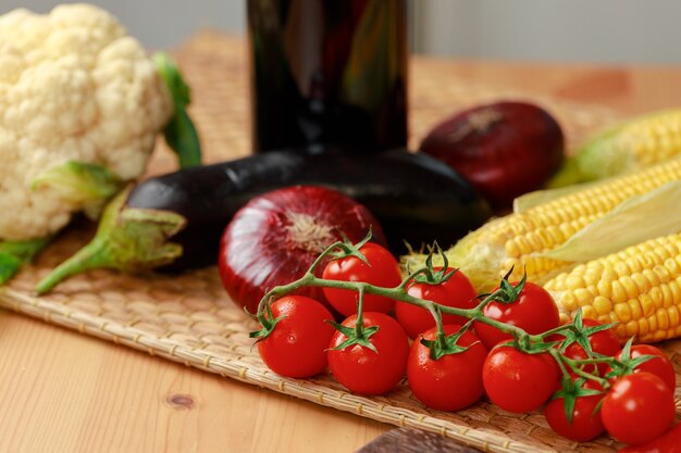 Foto tomates cherry, maíz y cebolla en mesa de madera