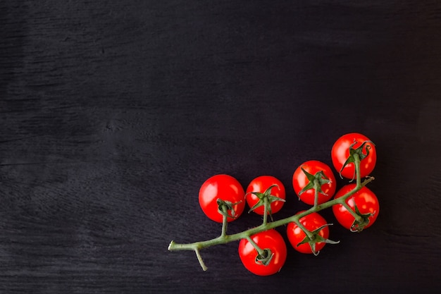 Tomates cherry en una mesa de madera negra. Copia espacio Fondo para cafetería, menú, libro de cocina para recetas, restaurante.