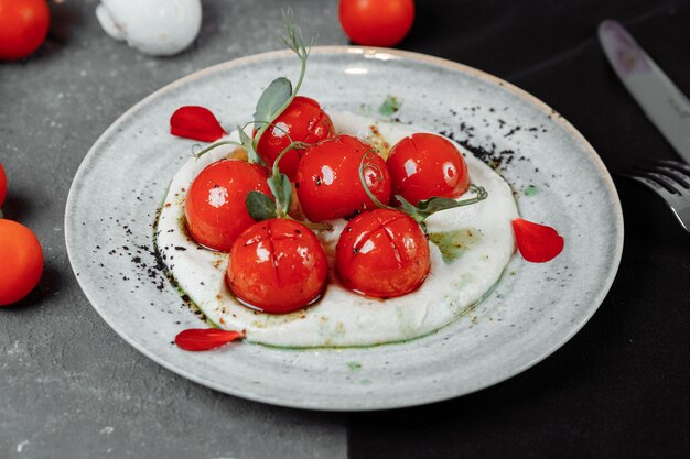 tomates cherry con mousse de tofu en un plato.