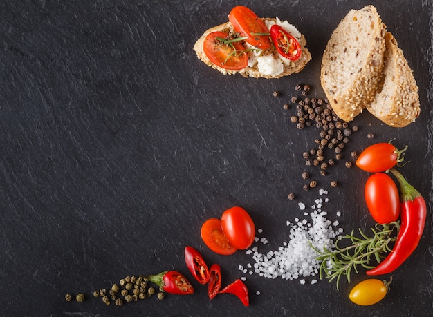 Tomates cherry en pizarra con pan de molde, bruschetta y sal.