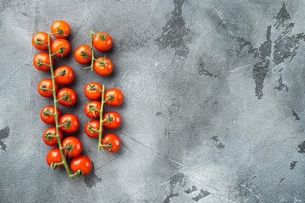 Tomates cherry en rama, en piedra gris