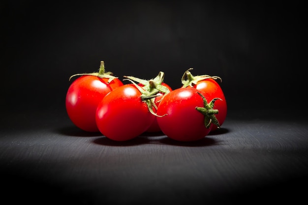 Tomates cherry rojos aislados en negro