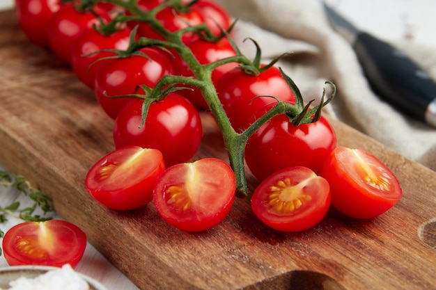 Tomates cherry rojos frescos sobre fondo blanco de madera