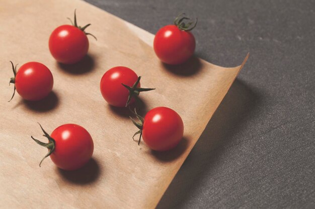 Tomates cherry rojos frescos sobre un fondo de papel marrón