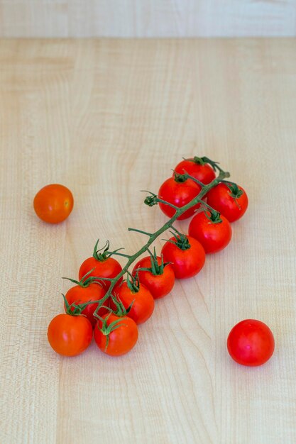 Tomates cherry rojos maduros en una mesa de madera