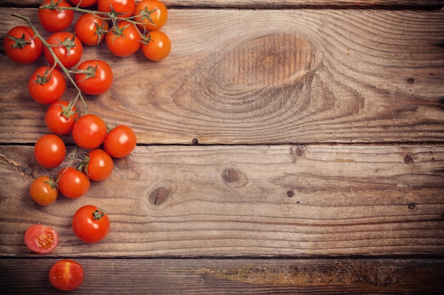 Tomates cherry sobre fondo de madera rústica