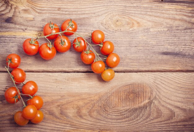 Tomates cherry sobre fondo de madera rústica