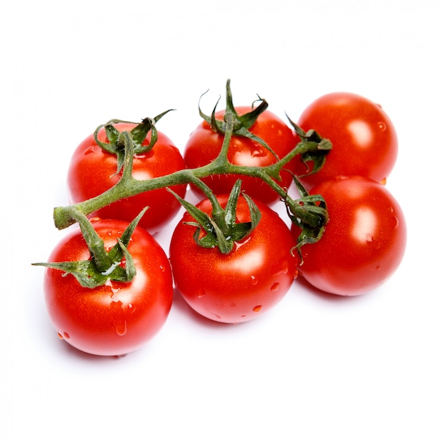 Tomates ciruela con hojas en blanco aislado