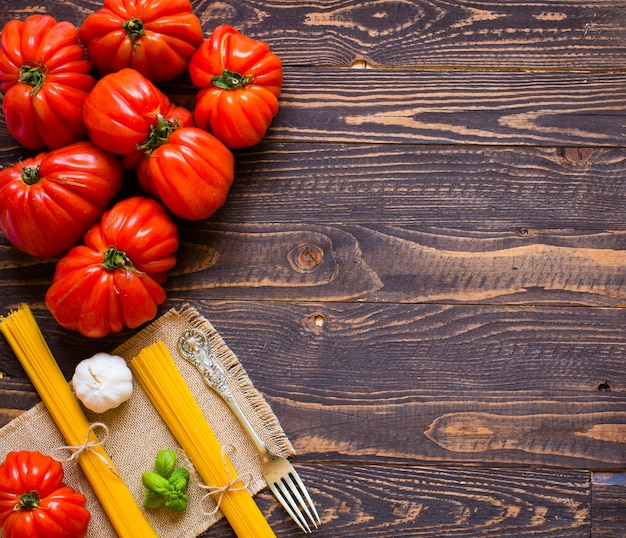 Tomates de corazón de buey, sobre fondo de madera rústica, espacio libre para texto.