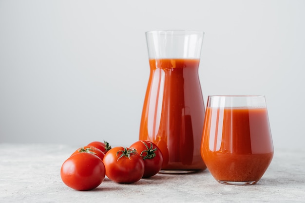 Tomates crudos y vaso de bebida fresca