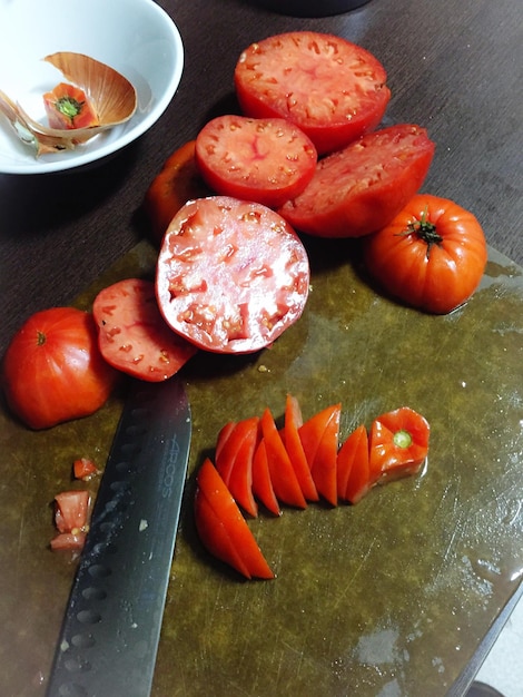 Foto tomates y cuchillo en la tabla de cortar