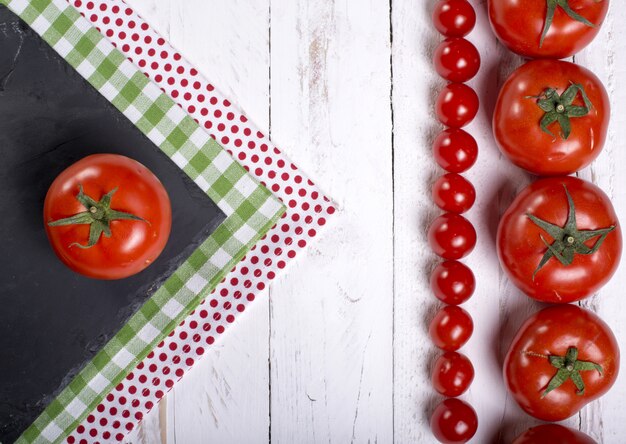 Tomates de quadro em fundo branco de madeira