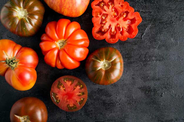 Tomates de variedades diferentes em um fundo preto.