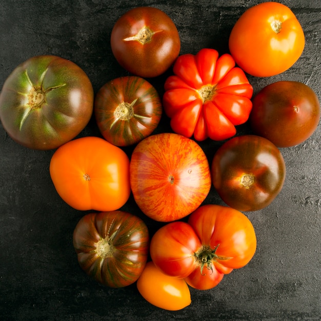 Tomates de variedades diferentes em um fundo preto.